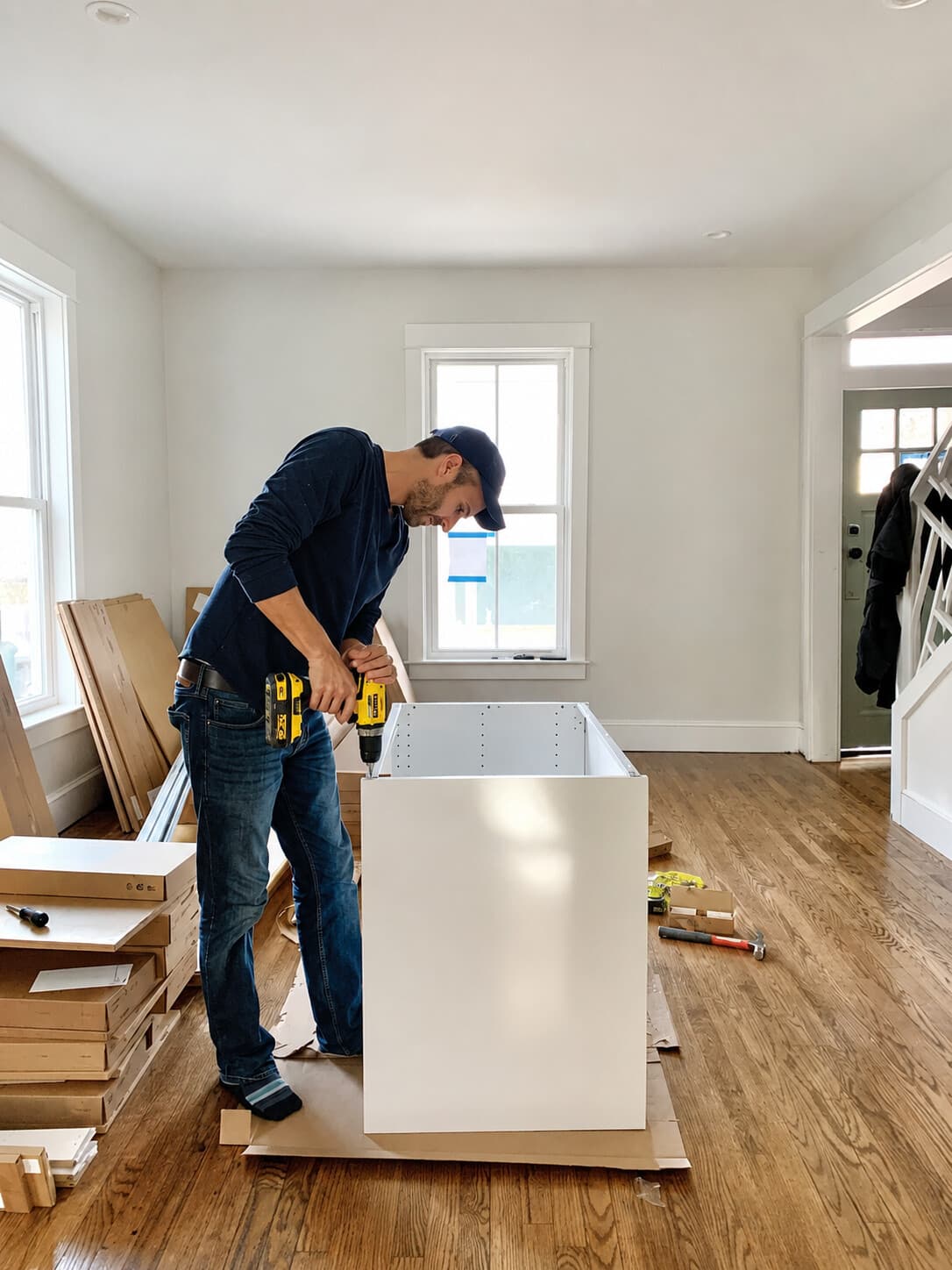 Technician assembling a large credenza cabinet in a home entryway