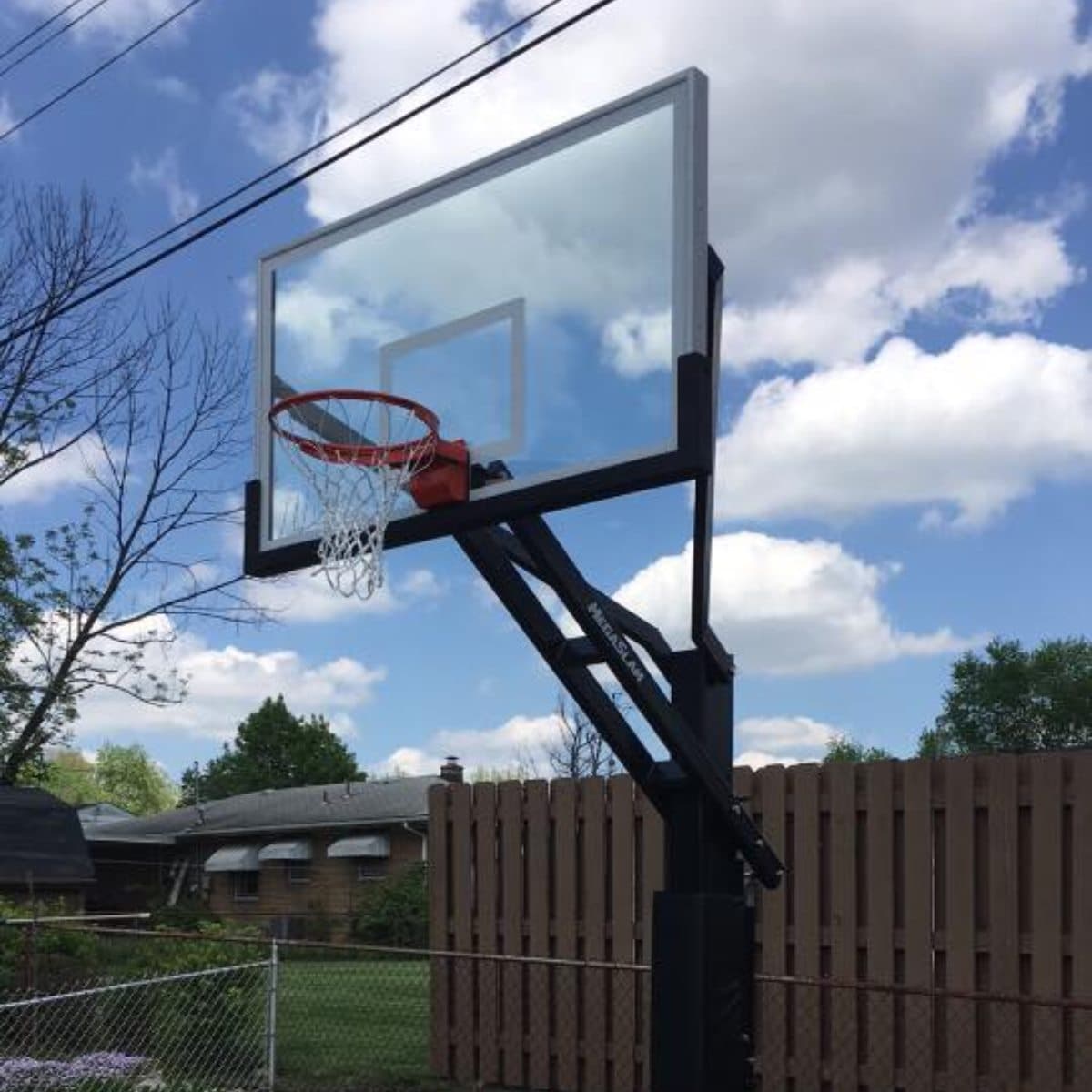 Completed in-ground basketball hoop installation in a backyard