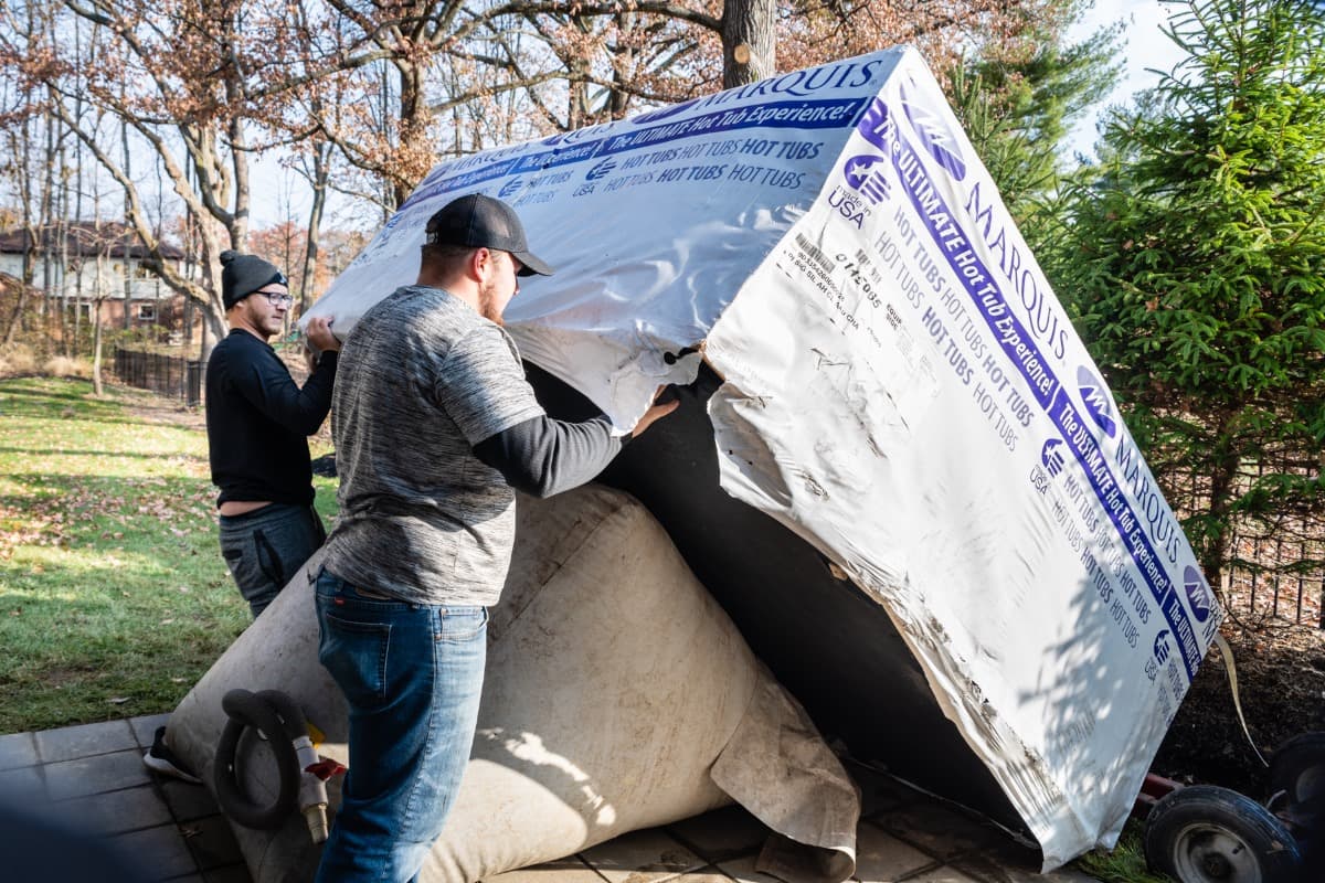 Crew unwrapping a new Marquis hot tub for delivery